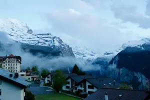Village buildings with snow-capped mountains and fog in the valley. jigsaw puzzle