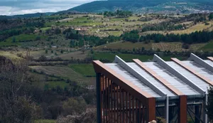 Modern building with a sloped roof overlooking rolling hills jigsaw puzzle