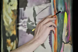 person holding paint brush while painting jigsaw puzzle