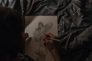 a person drawing a picture on a sheet of paper jigsaw puzzle