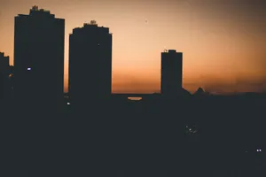 A striking silhouette of skyscrapers against a colorful sunset over the city skyline. jigsaw puzzle