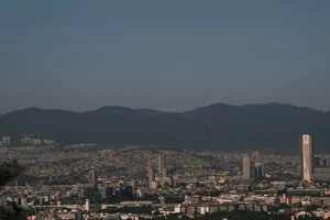 A panoramic view of Izmir's skyline against a mountain backdrop under a clear sky. jigsaw puzzle