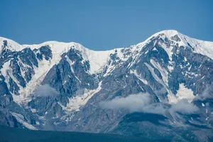 Stunning view of snow-covered mountains under clear blue sky. Ideal for winter travel inspiration. jigsaw puzzle