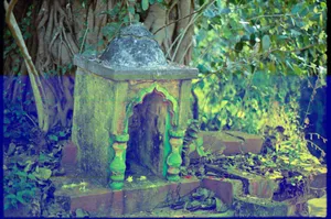 An ancient stone shrine surrounded by dense, overgrown vegetation in a forest setting. jigsaw puzzle
