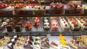 An enticing display of various cakes and desserts in a bakery shop, perfect for sweet indulgence. jigsaw puzzle