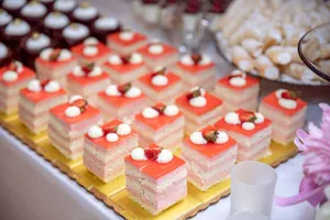 A tempting assortment of layered strawberry dessert slices with whipped cream on a dessert table. jigsaw puzzle