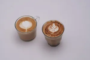 Two glass cups of latte with intricate latte art on white background. jigsaw puzzle