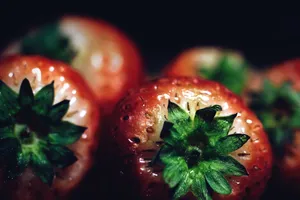 Vibrant close-up of fresh strawberries highlighting their juicy red texture and green leaves. jigsaw puzzle