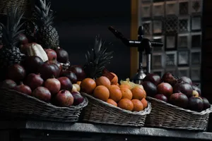 A colorful display of fruit baskets with pineapples, pomegranates, and oranges outdoors. jigsaw puzzle