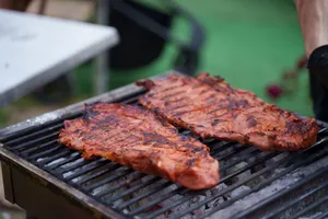 Juicy grilled steaks sizzling on an outdoor charcoal barbecue with vibrant summer vibes. jigsaw puzzle