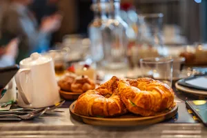 Close-up of croissants on a café table with elegant dining setting, perfect for breakfast. jigsaw puzzle