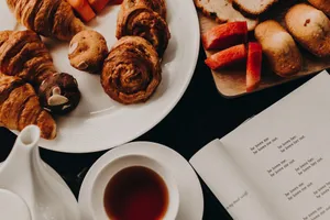 A delightful breakfast arrangement featuring croissants, pastries, and a cup of tea for a cozy morning. jigsaw puzzle