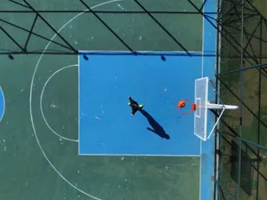 Drone shot capturing a person on a basketball court, showcasing athletic movement from an aerial perspective. jigsaw puzzle