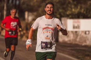 Man smiling while running an urban marathon in sportswear under warm sunlight. jigsaw puzzle