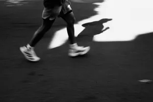 Captivating black and white image of a runner's shadow casting on the pavement in motion. jigsaw puzzle
