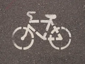 Close-up of a white bicycle lane marking on asphalt, showcasing urban cycling infrastructure. jigsaw puzzle