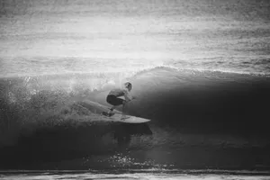 Black and white photo of a surfer riding a wave, capturing the thrill of surfing at sea. jigsaw puzzle