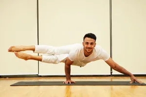 A man balances in an advanced yoga pose on a mat indoors, showcasing strength and focus. jigsaw puzzle