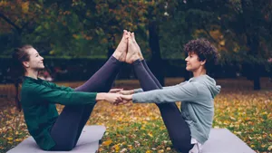 Two women practicing partner yoga outdoors on a fall day, surrounded by colorful leaves. jigsaw puzzle