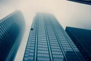 Captivating view of modern skyscrapers reaching into foggy skies, symbolizing urban growth. jigsaw puzzle