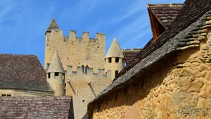 A beautiful medieval castle with stone towers and gothic architecture against a clear blue sky. jigsaw puzzle