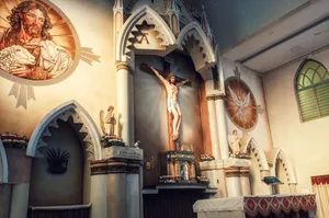 A detailed view of a church altar featuring a crucifix and religious icons in a serene indoor setting. jigsaw puzzle