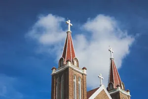 Two gothic-styled church towers with crosses against a vivid blue sky in Vietnam. jigsaw puzzle