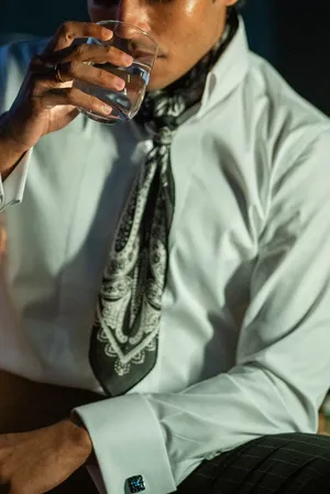 Man in vintage attire drinking water, exuding elegance and class. jigsaw puzzle