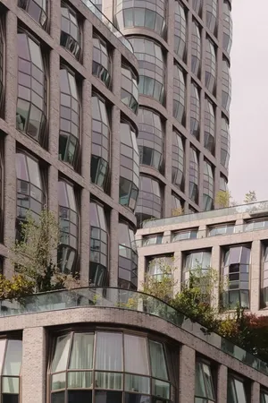 Curved glass buildings with lush greenery in NYC's urban landscape. jigsaw puzzle