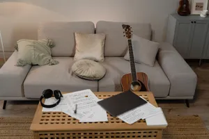 A comfortable home setting featuring a guitar on a sofa, ideal for music creation. jigsaw puzzle