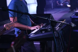 A musician performs on a keyboard during a dynamic live concert, surrounded by instruments. jigsaw puzzle