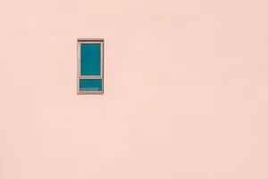 A minimalist pastel pink wall featuring a single rectangular window, offering ample negative space. jigsaw puzzle