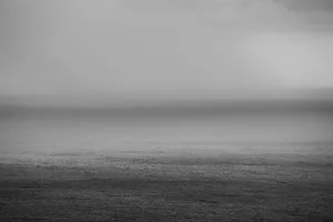 A tranquil grayscale view of the open sea under a calm sky, evoking serenity and minimalism. jigsaw puzzle
