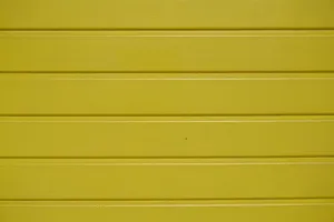 Close-up of a vibrant yellow wooden wall with textured planks. jigsaw puzzle