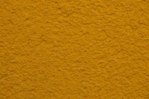 Close-up of a textured yellow plaster wall, ideal for backgrounds or design projects. jigsaw puzzle