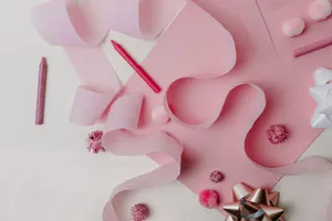 Flat lay of pink craft supplies and decorations featuring ribbons and bows on a pastel background. jigsaw puzzle