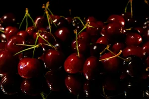 a pile of cherries sitting on top of a table jigsaw puzzle