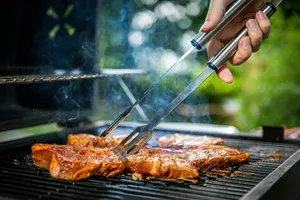 person holding gray tongs on barbecue jigsaw puzzle