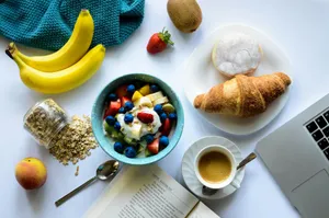 top view of strawberry and berries parfait in bowl near croissant and laptop jigsaw puzzle