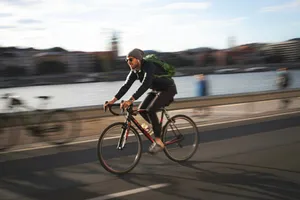 man in black jacket riding on black bicycle on road during daytime jigsaw puzzle