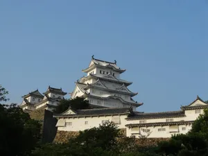 a large building with many rooftops with Himeji Castle in the background jigsaw puzzle