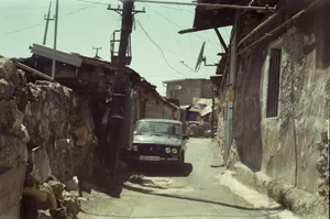 A car drives down a narrow, old street. jigsaw puzzle