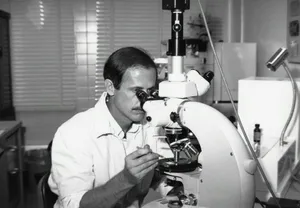 a black and white photo of a man looking through a microscope jigsaw puzzle