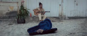 A man playing a guitar in front of a garage jigsaw puzzle