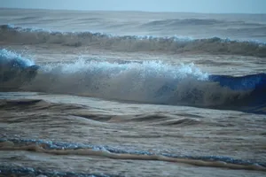 Capture of powerful ocean waves crashing onto the shoreline under a clear sky. jigsaw puzzle
