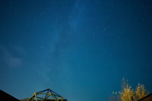 A stunning long exposure photograph capturing a star-filled night sky with subtle cloud formations and tree silhouettes. jigsaw puzzle