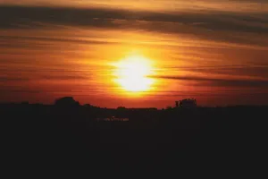Beautiful sunset with vibrant orange hues over a dark silhouetted horizon. jigsaw puzzle