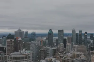 Aerial view of Montreal's skyline showcasing the city's modern skyscrapers under a cloudy sky. jigsaw puzzle