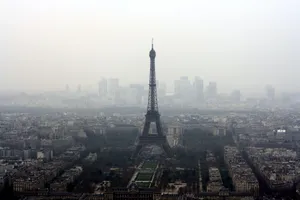 A foggy view of the Eiffel Tower rising above the Paris cityscape, capturing the city's iconic architecture. jigsaw puzzle