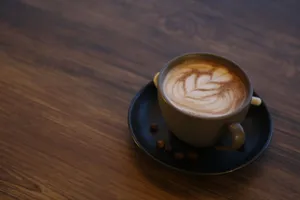 Close-up of an artistic latte with coffee beans on a wooden table, perfect for coffee lovers. jigsaw puzzle